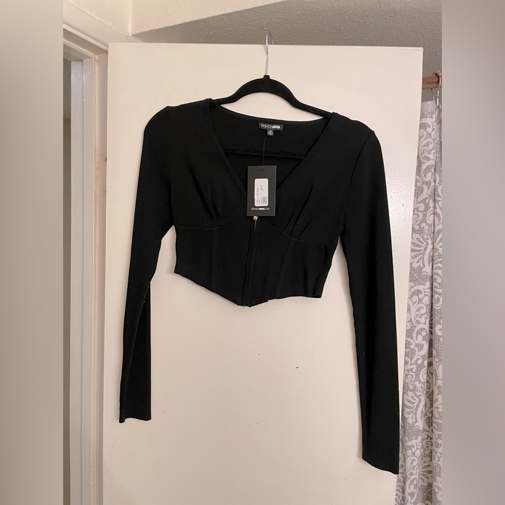 Black knit long sleeve cropped top .